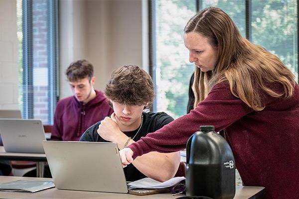 Instructor assisting student with assignment 